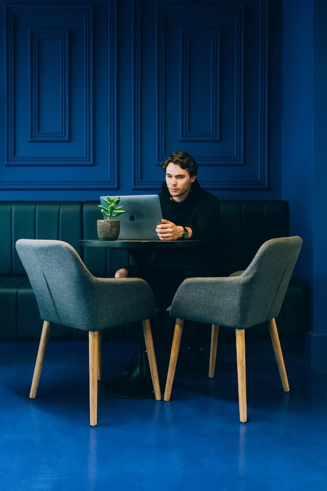 Man sitting at a desk looking at his laptop